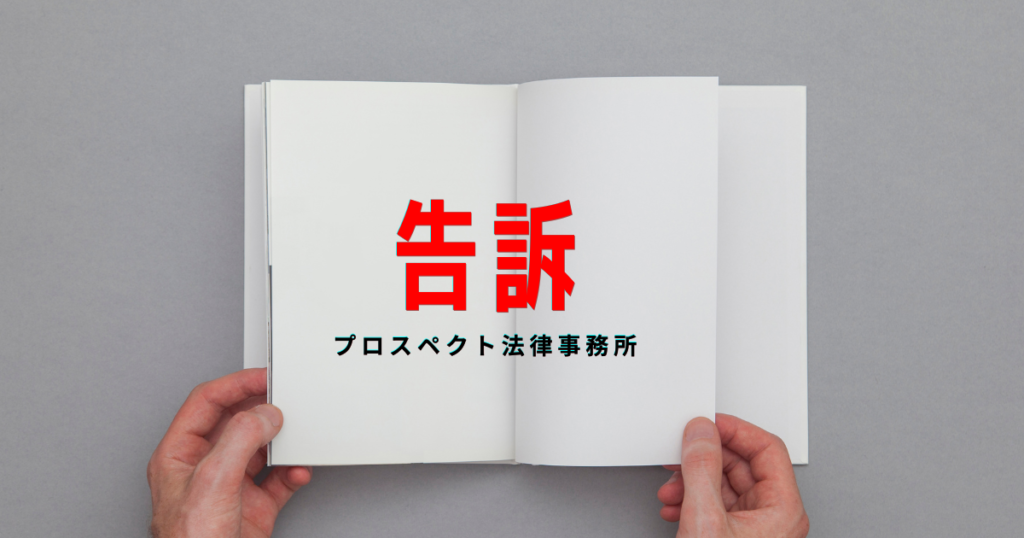相談室の机に置かれた告訴状のような書類とペンを前に、静かに話し合う人物の手元