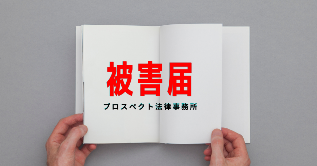 警察署の相談窓口を連想させる机に置かれた被害届の書類とペン